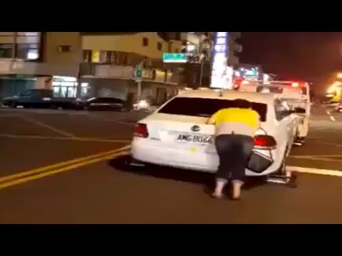 بالفيديو سائقة تايوانية تزحف خلف سيارتها المسحوبة بالونش