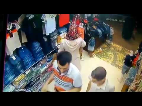 بالفيديو  فتاة تسرق حقيبة شخص داخل محل ملابس