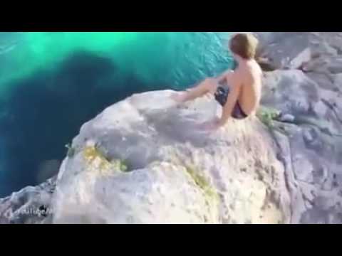 لحظة سقوط فتاة من فوق صخرة شاهقة العلو في البحر