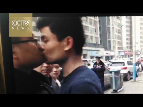 شاهد صيني يقبل ضابط شرطة أثناء إزالة مطعمه المخالف